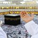 How to Make Umrah a Sustainable Journey: Top Eco-Friendly Practices 2 Muslim praying in Makkahh with hands up