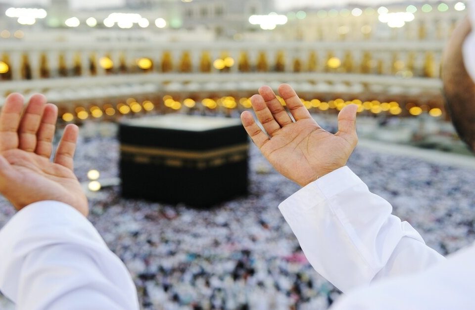 Muslim praying in Makkahh with hands up